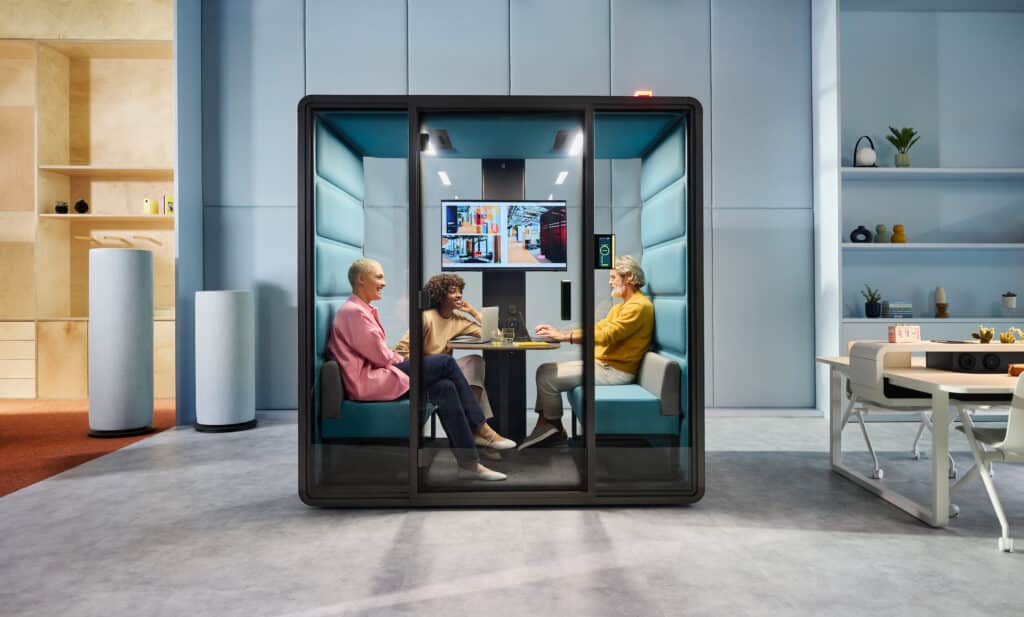 Drei Personen in moderner Arbeitskabine im Büro.