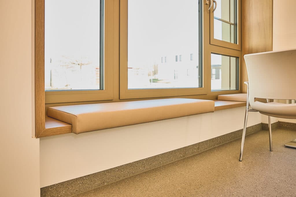 Fensterbank mit Kissen und Sessel Innenansicht.