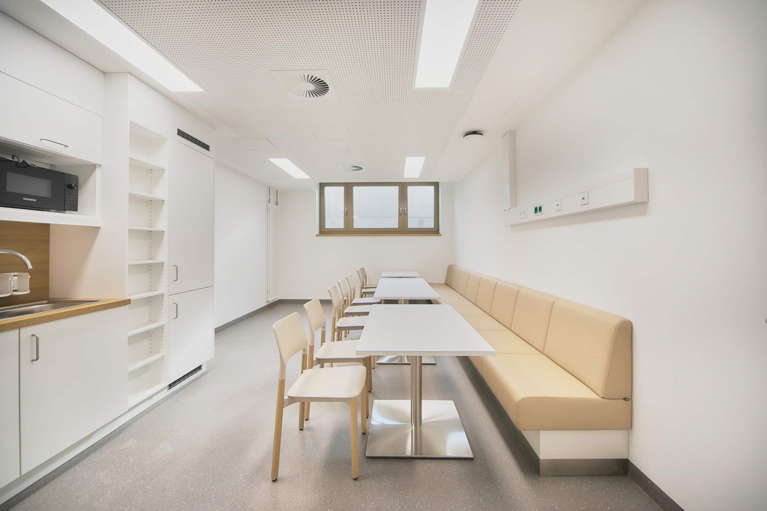 Moderner Pausenraum mit Tischen und Stühlen