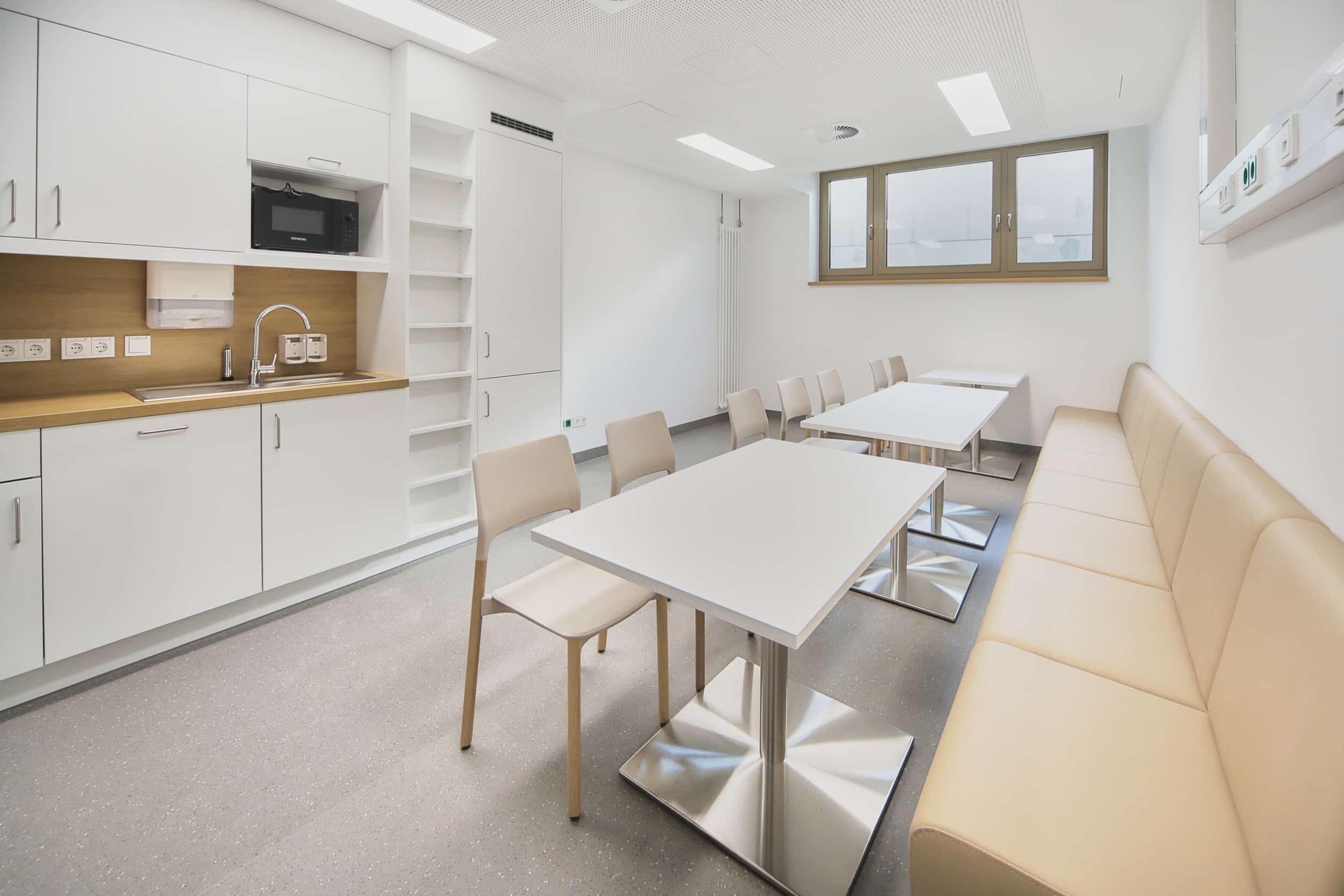 Moderne Kantine mit Tischen und Stühlen.