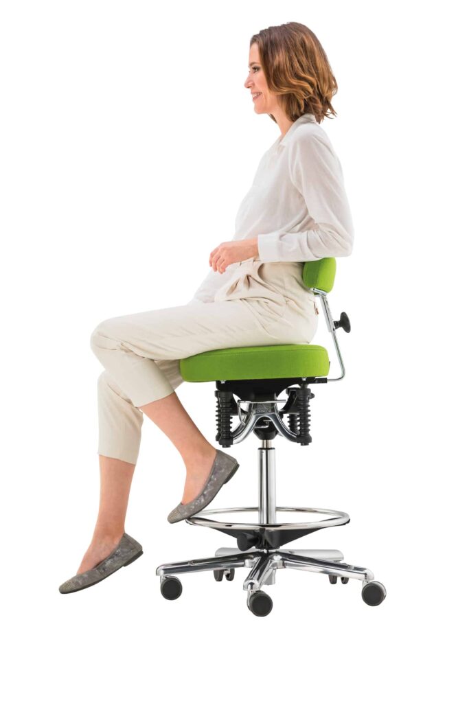 Frau sitzt auf ergonomischem Bürostuhl, lächelnd.